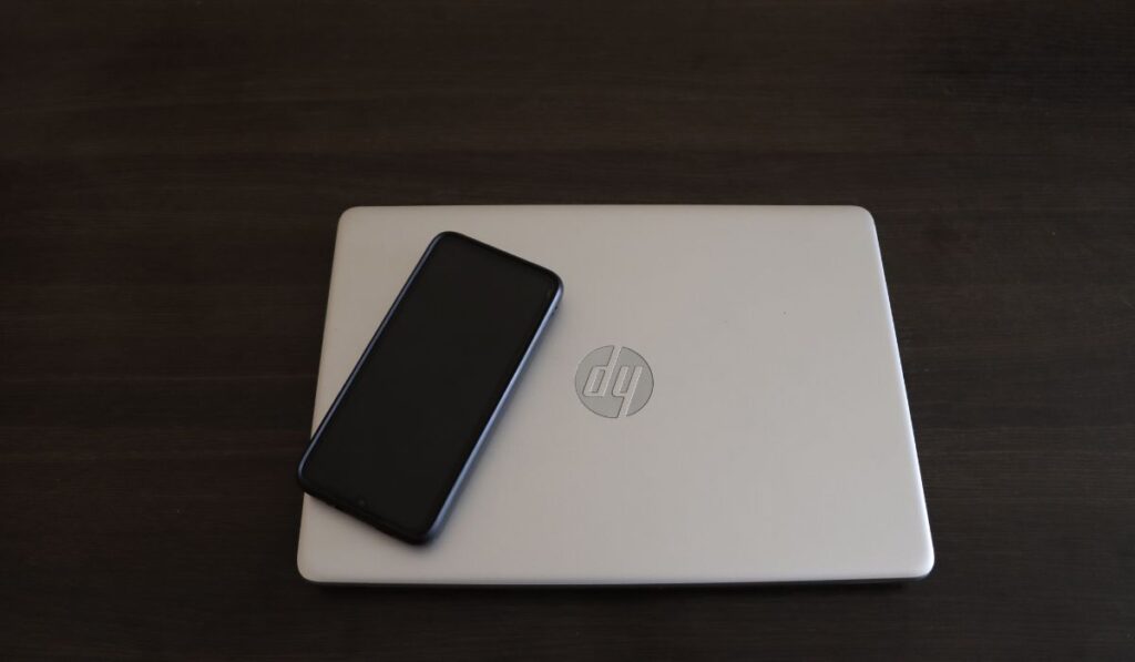 Close-Up Shot of a Smartphone on top of a HP Laptop