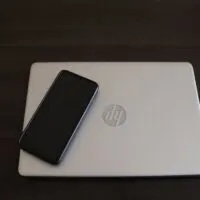 Close-Up Shot of a Smartphone on top of a HP Laptop