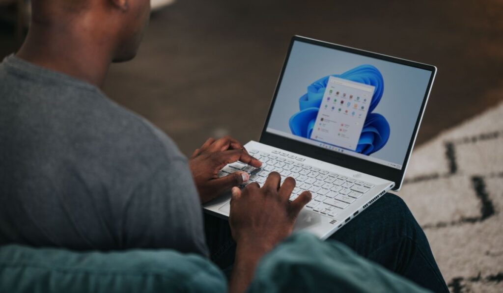 Person working on Windows 11 computer on the couch