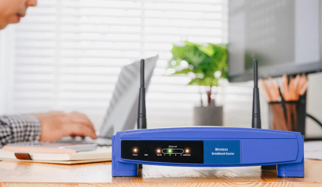 wifi router on a table with a man working on a laptop in the background