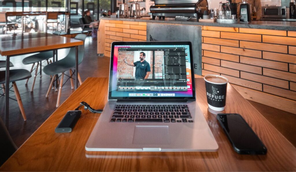 A Macbook Pro with a Final Cut Pro open in a coffee shop