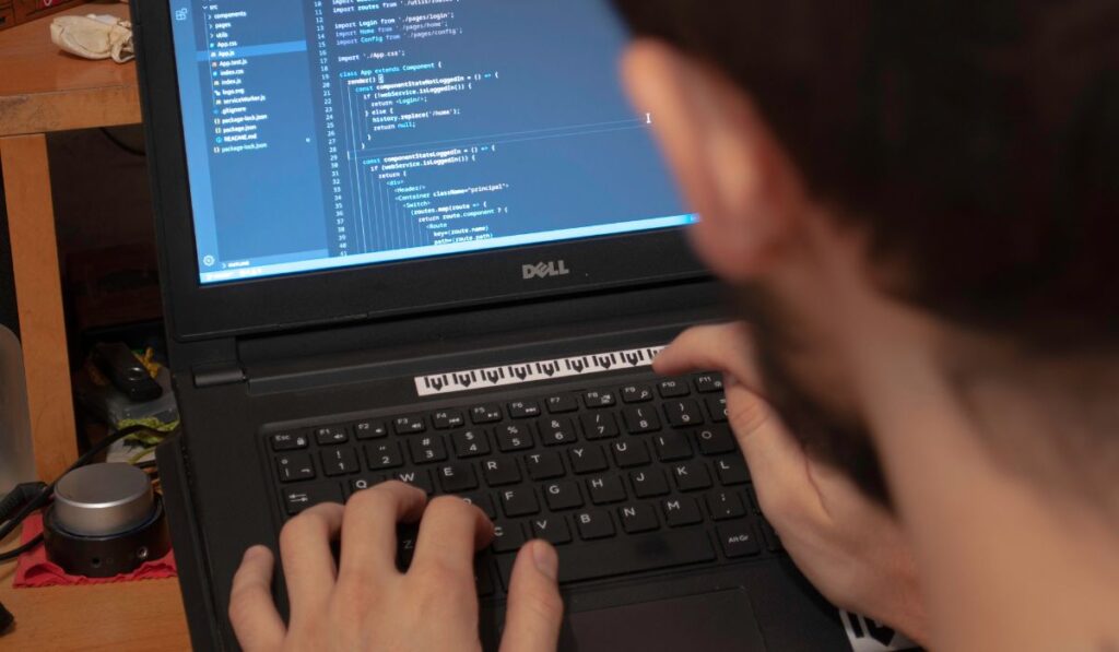 Человек, использующий черный портативный компьютер Dell