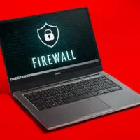 Dell laptop displaying an image with code and the word 'fire wall' with a lock icon