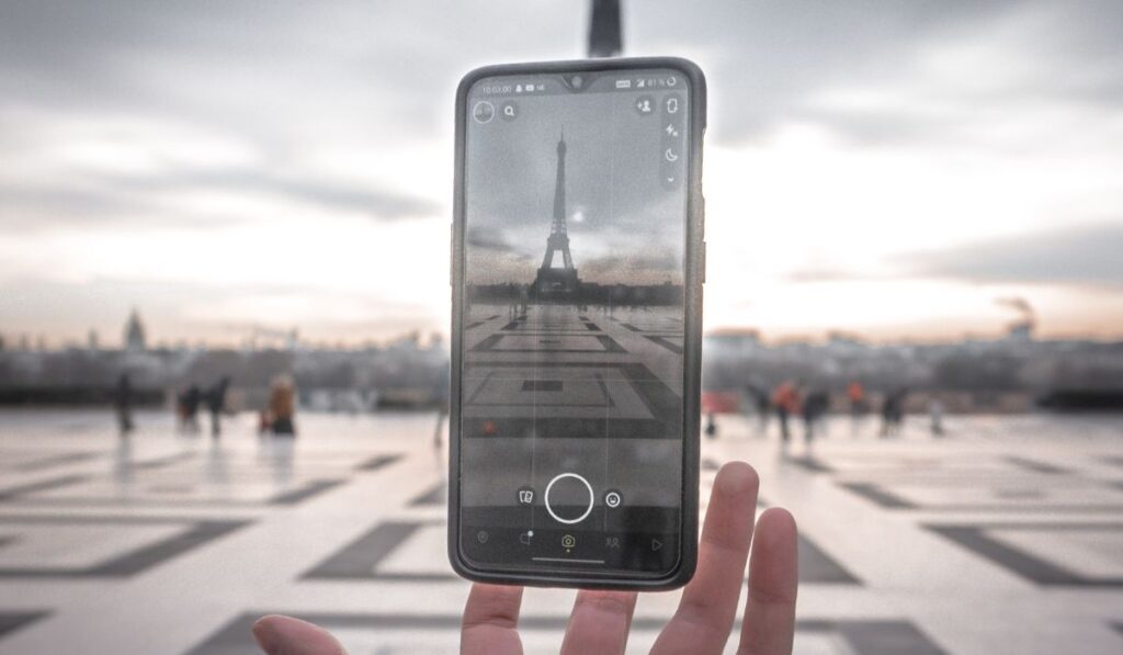 Hand and phone in front of eiffel tower
