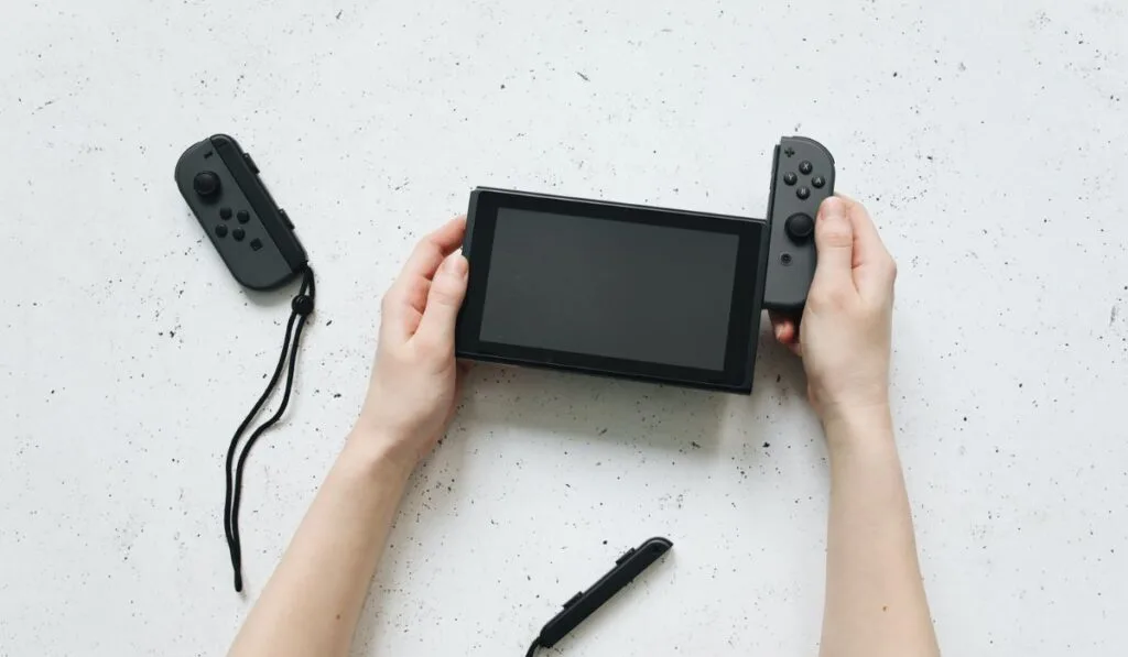 Hands Removing the Controller of Nintendo Switch